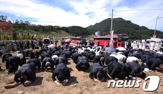 본문 이미지 - 통일교 창시자 고 문선명 총재의 3남 문현진 통일세계재단 회장과 함께 조문 온 신도들이 11일 오후 경기도 가평군 설악면 청심평화월드센터 앞 길거리에서 시신이 안치된 천정궁을 향해 절을 하고 있다. © News1 박철중 기자
