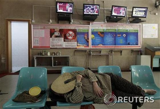 본문 이미지 - 한 투자자가 지난 6월 허페이성 우한시에 위치한 증권업체 객장에서 잠시 낮잠을 자고 있다.  © 로이터=News1  