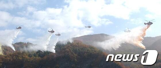 본문 이미지 - 개청 41주년을 맞은 산림항공본부가 19일 오전 산림항공 역사 40년을 담은 ‘산림항공본부 40년사’ 출판기념회를 갖는다. 사진은 산불 현장에서 진화작업을 벌이고 있는 산림항공본부 소속 헬리콥터들의 편대비행 장면. © News1 