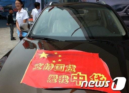본문 이미지 - 지난 21일 중국 허난성 이창에서 열린 오토쇼에 전시된 한 자동차. '국산품 애용으로 중국을 사랑하자'는 스티커를 붙이고 있다. © News1 
