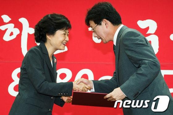 본문 이미지 - 2012년 9월 28일 박근혜 새누리당 대선후보가 대구광역시 수성구 범어동 대구시당에서 열린 대통령선거대책위 출범식에서 유승민 대구선대위원장에게 임명장을 수여하고 있다. 2012.9.28 ⓒ 뉴스1