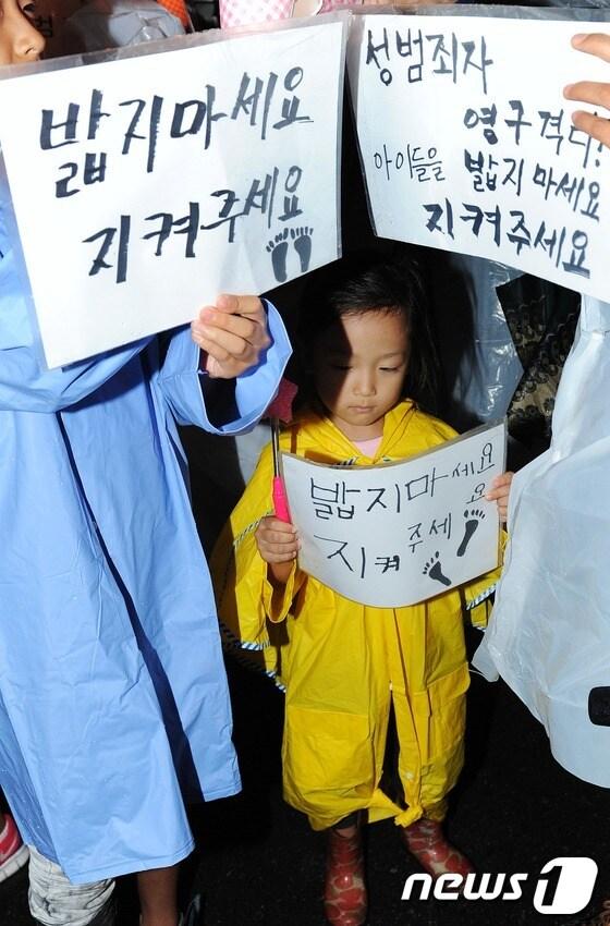 본문 이미지 - 급증하는 아동 대상 흉악범죄가 큰 사회적 문제로 대두되고 있는 가운데 4일 저녁 서울역광장에서 열린 아동 성폭력 추방을 위한 시민모임 '발자국' 주최 아동 성폭력 추방 촉구 집회에서 부모와 함께 참가한 한 어린이가 '밟지마세요, 지켜주세요'라고 적힌 손팻말을 들고 있다. 2012.9.4/뉴스1 © News1 오대일 기자