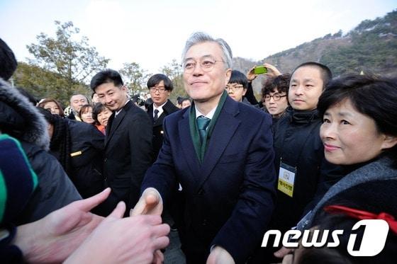 본문 이미지 - 민주통합당 문재인 전 대선후보가 계사년 새해 첫날인 1일 오전 경남 김해시 봉하마을 노무현 전 대통령 묘역 참배를 마치고 지지자들과 인사를 나누고 있다. 이번 참배행사에서는 노건호씨와 이병완 노무현재단 이사장, 참여정부 인사, 전국에서 모인 지지자들을 비롯해 많은 인파가 모였다. 2013.1.1/뉴스1 © News1 전혜원 기자