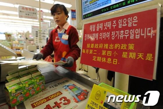 본문 이미지 -  서울 한 대형마트 계산대에 의무휴업을 알리는 안내판이 붙여있다.   2013.1.15/뉴스1 © News1   박세연 기자