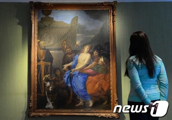 본문 이미지 - 프랑스 리츠호텔 보수 공사 중 스위트룸에서 17세기 유명화가 샤를 르브룅의 초기 작품이 발견됐다. 크리스티 경매장 직원이 '폴리크세나의 희생'으로 명명된 이 작품을 감상하고 있다. ©AFP=News1 