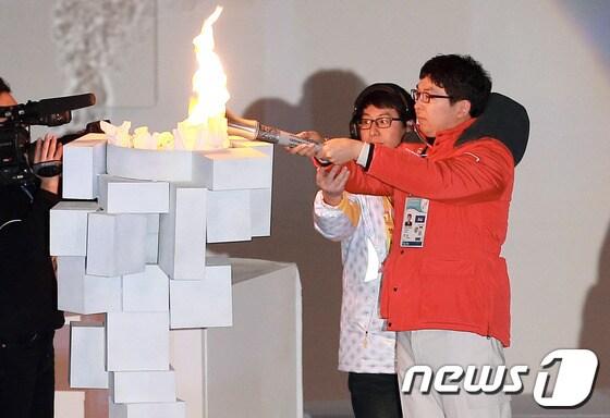 본문 이미지 - 전 세계 지적 장애인들의 겨울축제 '2013 평창동계스페셜올림픽'이 막을 올린 29일 강원도 평창군 용평돔에서 열린 개막식에서 대한민국 스노보드 황석일 선수가 성화를 점화하고 있다. 2013.1.29/뉴스1 © News1   오대일 기자