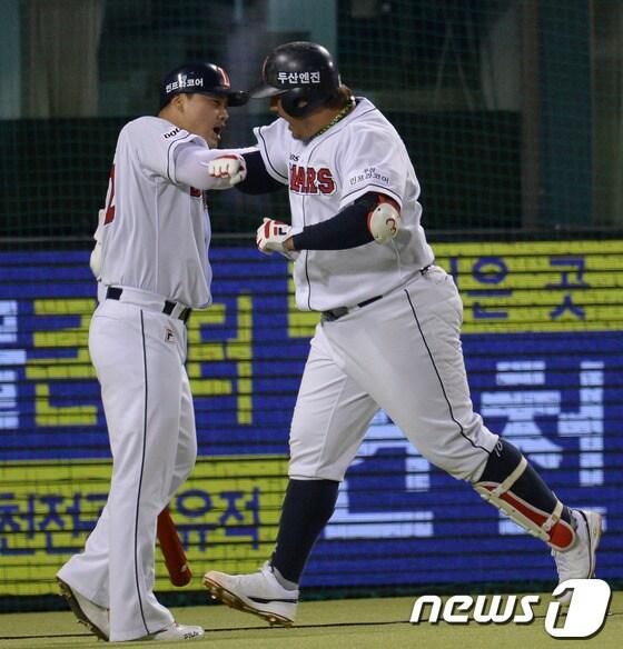 본문 이미지 - '2013한국야쿠르트 세븐 프로야구' 준플레이오프(PO) 3차전 두산 베어스와 넥센히어로즈의 경기가 11일 서울 잠실야구장에서 열렸다.두산 4회말 2사 상황 최준석이 좌측담장을 넘기는 솔로홈런을 날린 후 홈에서 홍성흔의 축하를 받고 있다. 2013.10.11/뉴스1 © News1   이동원 기자