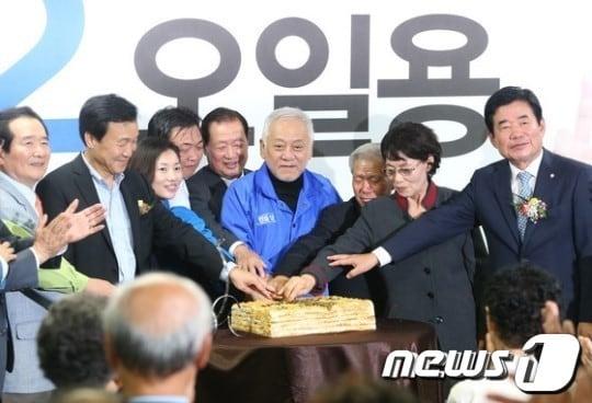 본문 이미지 - 김한길 민주당 대표와 손학규 상임고문, 재보선 경기 화성갑에 출마한 오일용 후부가 13일 경기 화성시 봉담읍에서 열린 오 후보의 선거사무실 개소식에서 선거 승리를 기원하며 떡을 자르고 있다. © News1 