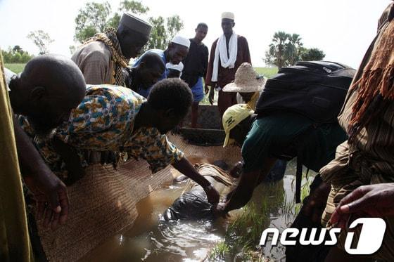 본문 이미지 - 13일&#40;현지시간&#41; 말리 니제르강에서 발생한 여객선 침몰사고로 인해 최소 39명이 사망했다. 사고지역 인근 코우비 주민들이 사망자의 시신을 수습하고 있다.© AFP=News1 
