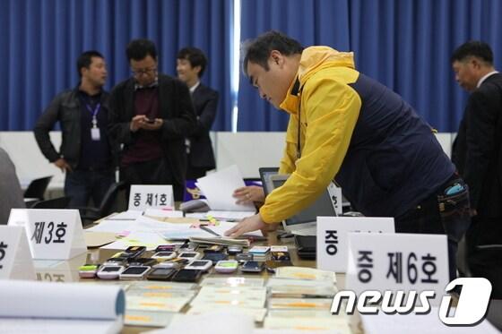 본문 이미지 - 조폭낀 대출사기단이 범행에 사용했던 대포폰과 대포통장 등 압수품 © News1 