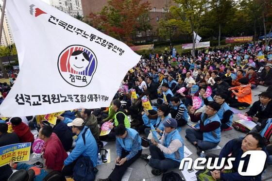 본문 이미지 - 전국교직원노동조합&#40;전교조&#41; 회원들이 19일 오후 서울 서대문 독립공원에서 열린 전국 교사 결의대회에서 &#39;힘내라 전교조&#39; 등의 구호가 쓰인 부채를 흔들고 있다. 전교조는 총투표를 통해 해직자를 조합원에서 배제하라는 정부 명령을 최종 거부하고 설립 14년 만에 법외노조를 택했다. 오는 23일 법외노조를 통보 받으면 전교조는 노조 지위를 박탈당해 법외노조가 되며 교육부나 시도교육청과 단체협약 교섭, 체결권 등을 잃게 된다. 2013.10.19/뉴스1 © News1   안은나 기자