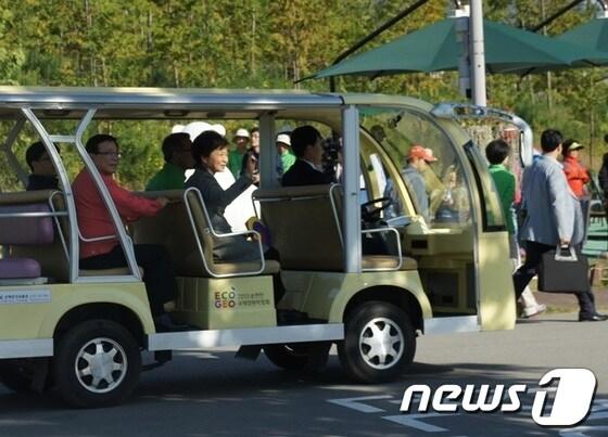 본문 이미지 - 2013순천만 국제정원박람회장을 방문, 전동카트를 타고 이동하는 동중 환호하는 관람객들을 향해 손을 흔들고 있다.© News1 서순규기자