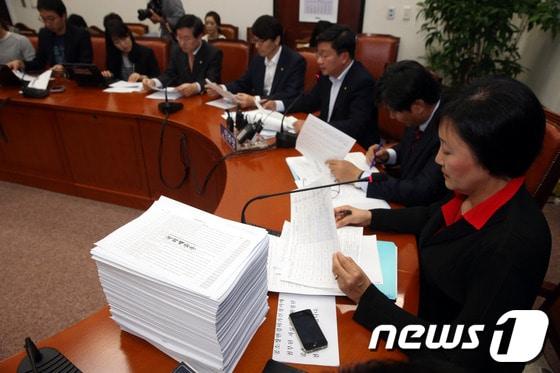 본문 이미지 - 지난 20일 오후 서울 여의도 국회에서 열린 야당 법사위원 국정원 SNS 대선개입 추가 의혹 제기 관련 기자간담회에서 법사위 위원장인 박영선 민주당 의원 앞에 트위터를 통해 대선개입 활동을 한 정황이 담긴 자료가 수북히 쌓여 있다. /뉴스1 © News1 이광호 기자