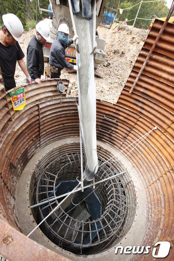 본문 이미지 - 한전이 송전탑 공사를 재개한지 21일째인 22일 경남 밀양시 단장면 84번 송전탑 공사현장에서 시공업체 직원들이 콘크리트 작업을 벌이고 있다. © News1 