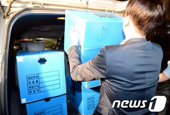 본문 이미지 - 이석채 KT 회장 자택과 KT본사, 계열사 등에 대한 압수수색을 벌인 검찰이 22일 오후 서울 서초동 KT서초사옥에서 압수물품을 담은 상자를 옮기고 있다.이 회장은 지난 2010~2012년 KT사옥 39곳을 매각하는 과정에서 투자자들에게 최대 869억원에 달하는 손해를 끼친 혐의로 검찰의 조사를 받고 있다. 2013.10.22/뉴스1 © News1   정회성 기자