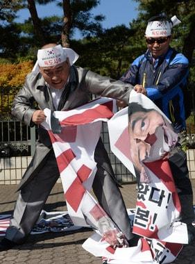 본문 이미지 - 독도의 날을 맞은 25일 애국국민운동대연합 회원들이 서울중앙지검 앞에서 일본 아베총리 사진이 들어간 욱일승천기를 찢고 있다. 2013.10.25/뉴스1 © News1 손형주 기자