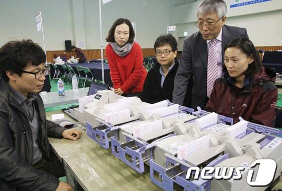 본문 이미지 - 10.30 화성갑 재보선을 하루 앞둔 29일 경기 화성시 화성종합경기타운 실내체육관에 마련된 개표소에서 선거관리위원회 직원들이 개표기를 점검하고 있다. 2013.10.29/뉴스1 © News1 송원영 기자