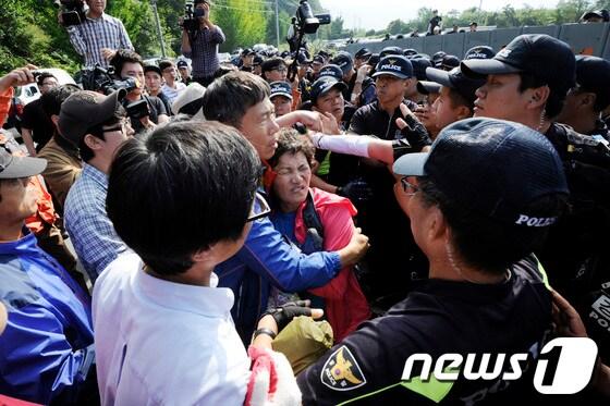 본문 이미지 - 밀양 송전탑 공사재개 이틀째인 2일 오후 밀양 단장면 단장리 765㎸ 신고리-북경남 송전선로 건설공사 4공구 현장사무소 앞에서 송전탑 반대 주민들과 집회 참가자들이 경찰과 몸싸움을 벌이고 있다. 2013.10.3/뉴스1 © News1 전혜원 기자
