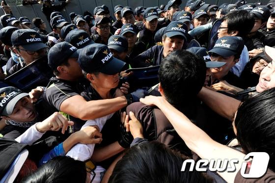 본문 이미지 - 밀양 송전탑 공사재개 이틀째인 2일 오후 밀양 단장면 단장리 765㎸ 신고리-북경남 송전선로 건설공사 4공구 현장사무소 앞에서 송전탑 반대 주민들과 집회 참가자들이 경찰과 몸싸움을 벌이고 있다. 2013.10.3/뉴스1 © News1   전혜원 기자
