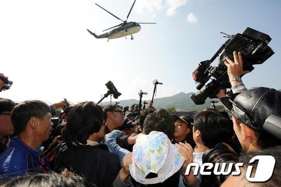 본문 이미지 - 밀양 송전탑 공사재개 이틀째인 3일 오후 밀양 단장면 단장리 4공구 현장사무소 앞에서 송전탑 반대 주민들과 집회 참가자들이 경찰과 몸싸움을 벌이는 가운데 상공에는 헬기가 자재를 옮기고 있다. 2013.10.3/뉴스1 © News1 전혜원 기자