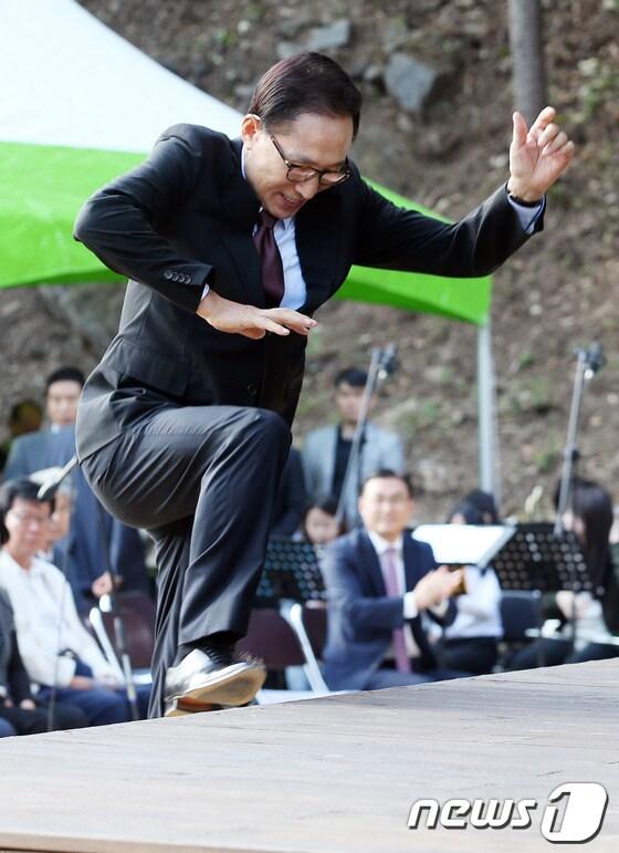 본문 이미지 - 이명박 전 대통령이 3일 오후 경기도 동두천시 광암동 두레마을 숲속창의력학교에서 열린 준공식에 참석해 축사를 하기 위해 단상을 뛰어 오르고 있다. 2013.10.3/뉴스1 © News1 허경 기자
