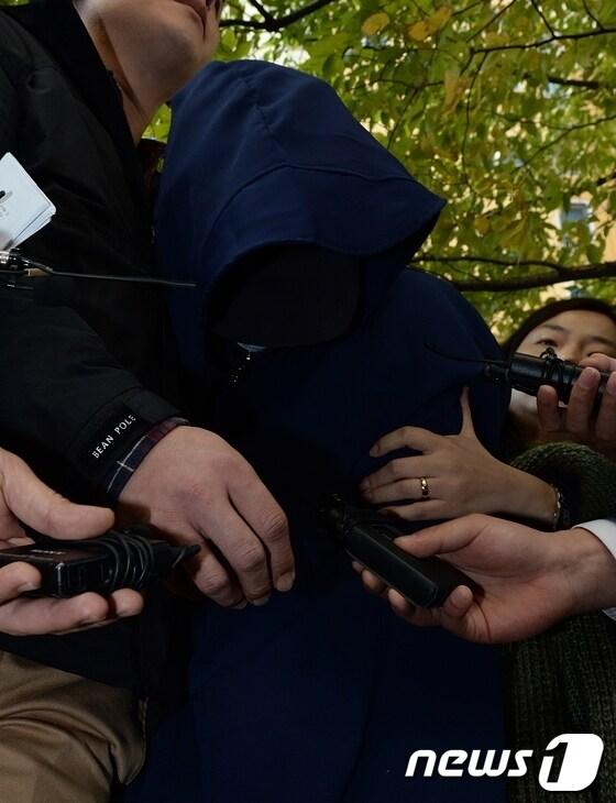 본문 이미지 - 거짓말을 한다며 8살 된 딸을 때려 숨지게 한 계모 박모(40)씨가 30일 오전 울산시 울주군 범서읍 자신의 아파트에서 현장검증 후 쏟아지는 취재진의 질문에 고개를 숙이고 있다. 2013.10.30/뉴스1 © News1 노화정 기자