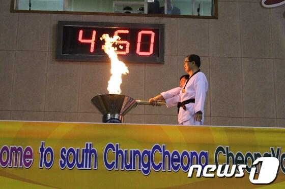 본문 이미지 - 칠갑산에서 출발한 성화가 마직막 주자인 김정숙 충남도의원으로부터 봉송되어 이석화 청양군수 와 아시아 태권연맹 장창재 총재가 성화대에 점화하고 있다.© News1조문현 기자 