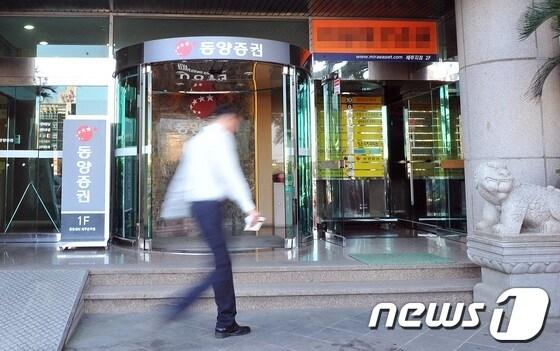 본문 이미지 - 동양증권 여직원 고모(42)씨 동양그룹 현재현 회장을 원망하는 유서를 남기고 스스로 목숨을 끊은 가운데  4일 고씨가 일했던 제주시의 동양증권 제주지점 앞으로 시민이 바삐 지나가고 있다.© News1 이상민 기자  