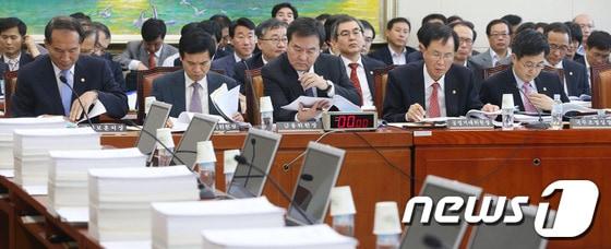 본문 이미지 - 신제윤 금융위원장과 노대래 공정거래위원장 등이 4일 오후 서울 여의도 국회에서 열린 정무위원회 전체회의에서 자료를 보며 회의 준비를 하고 있다. 2013.10.4/뉴스1 © News1   송원영 기자