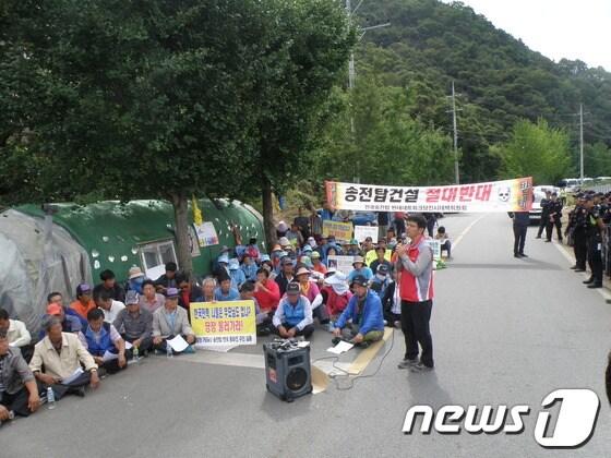 본문 이미지 - 경북 청도 주민과 충남 당진 주민 40여명 등으로 구성된 ‘전국송전탑반대네트워크’는 7일 낮 12시 밀양 단장면 단장리 공사장비 적치장 앞에서 기자회견을 열고 한전측의 무리한 공사 강행을 비난했다. © News1 박광석 기자