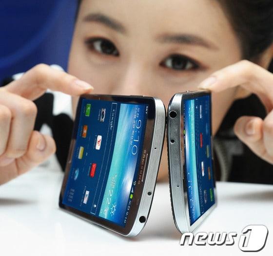 본문 이미지 - 삼성전자가 세계 최초로 휘어진 화면(플렉서블 디스플레이)을 탑재한 커브드 스마트폰 '갤럭시 라운드'를 출시한다고 9일 밝혔다.이 제품은 럭셔리 브라운 색상으로 SKT를 통해 출시될 예정이며 가격은 108만 9,000원이다. (삼성전자) 제공) 2013.10.9/뉴스1 © News1   