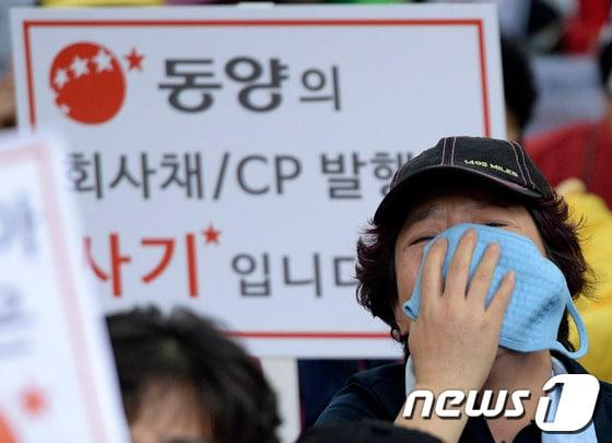 본문 이미지 - 동양그룹 사태 피해자가 9일 오후 서울 여의도 금융감독원 앞에서 열린 동양그룹 사태에 대한 피해 최소화와 대책 마련 항의 집회에서 눈물을 흘리고 있다.이날 집회 참가자들은 '피땀 흘린 서민들을 정부는 외면 말라', '고객 원금 보장하라' 등의 문구가 적힌 피켓을 들고 목소리를 높였다. 2013.10.9/뉴스1 © News1   박지혜 기자