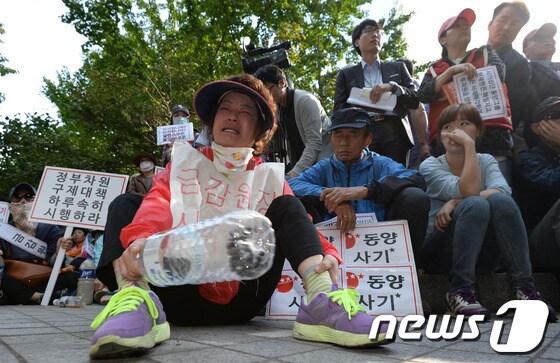 본문 이미지 - 동양그룹 사태 피해자가 9일 오후 서울 여의도 금융감독원 앞에서 동양그룹 사태, 피해 최소화와 대책 마련 항의 집회에서 눈물을 흘리고 있다.이날 집회 참가자들은 '피땀 흘린 서민들을 정부는 외면 말라', '고객 원금 보장하라' 등의 문구가 적힌 피켓을 들고 목소리를 높였다. 2013.10.9/뉴스1 © News1   박지혜 기자