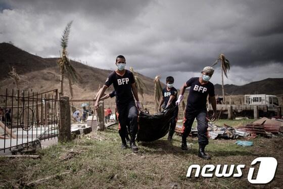 본문 이미지 - 수퍼 태풍 &#39;하이옌&#40;Haiyan&#41;&#39;으로 사망한 시신을 수습하고 있는 필리핀 보건당국 관계자들.© AFP=News1 이준규 기자