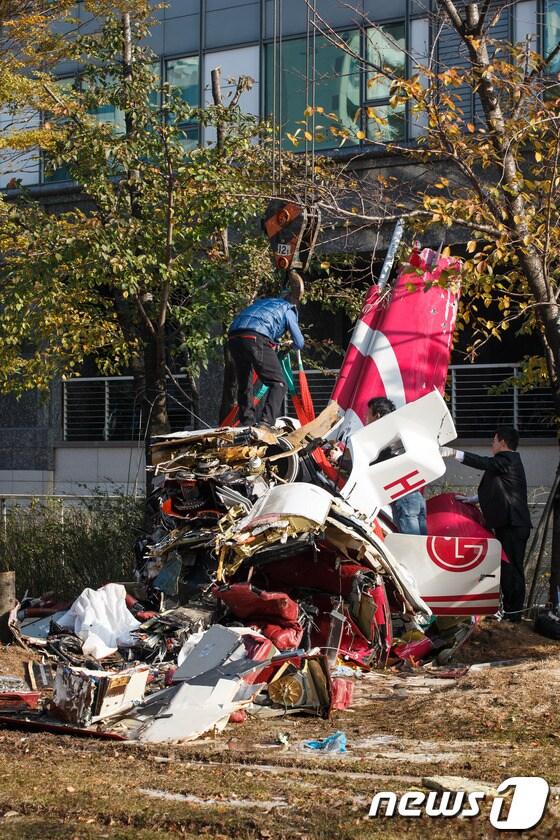 본문 이미지 - 16일 오전 서울 삼성동 아이파크 아파트에 민간 헬리콥터가 충돌해 추락하는 사고가 발생했다. 이날 오후 인부들이 추락한 헬기 잔해를 인양하고 있다. 이 사고로 기장과 부기장 등 2명이 사망한 것으로 알려졌다. 2013.11.16/뉴스1 © News1 유승관 기자