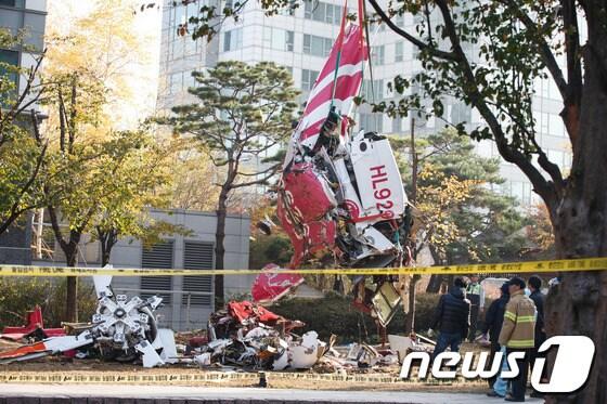 본문 이미지 - 16일 오전 서울 삼성동 아이파크 아파트에 민간 헬리콥터가 충돌해 추락하는 사고가 발생했다. 이날 오후 인부들이 추락한 헬기 잔해를 인양하고 있다.이 사고로 기장 1명과 부기장 1명이 사망했다. 2013.11.16/뉴스1 © News1 유승관 기자