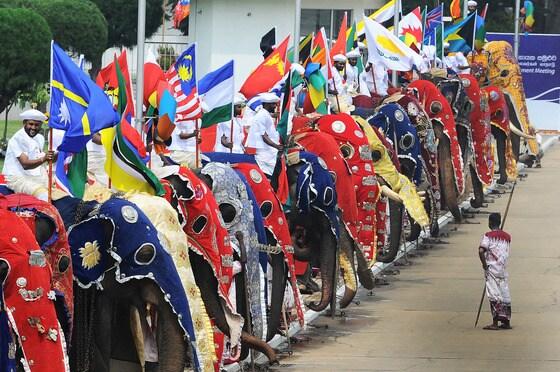본문 이미지 - 영연방정상회의 개막식이 열린 15일&#40;현지시간&#41; 스리랑카 수도 콜롬보의 반다라나이케  기념 국제회의장 밖에서 전통의상을 입고 코끼리 등에 올라탄 스리랑카인들이 회원국 국기를 들고 도열해 있다. 영국의 찰스 왕세자가 공식 개막식을 주재한 정상회의는 그러나 스리랑카의 철저한 준비에도 불구하고 내전 종식 당시 반군에 대한 인권탄압으로 촉발된 논쟁에 의해 빛이 바랬다.  ©AFP=뉴스1  