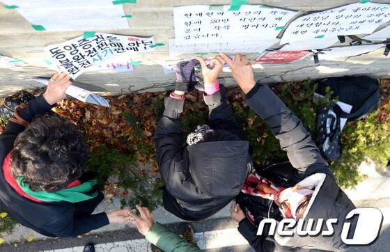 본문 이미지 - 동양그룹 피해자대책협의회가 지난해 11월 서울 성북구 성북동에 위치한 현재현 동양그룹 회장의 자택 앞에서 동양 CP-회사채 투자자들의 피해보상을 요구하는 집회를 연 뒤 항의문구가 적힌 손팻말을 담에 붙이고 있다. /뉴스1 © News1 정회성 기자