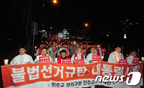본문 이미지 - 국가기관의 불법 대선 부정선거 규탄과 박근혜 대통령 사퇴를 촉구하는 시국미사가 열린 22일 오후 천주교정의구현사제단 신부들과 신자들이 전북 군산시 수송동 롯데마트 앞으로 걸어가며 '대통령 사퇴' 구호를 외치고 있다.각 종교계의 시국미사는 여러번 있었지만 대통령 사퇴를 촉구하는것은 이번이 처음이다.2013.11.22/뉴스1  © News1   김대웅 기자