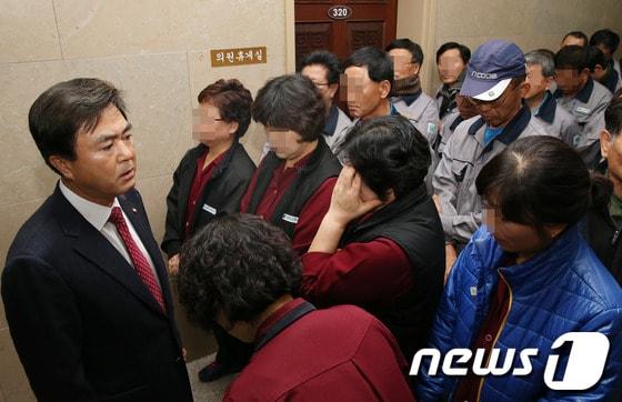 본문 이미지 - 김태흠 새누리당 의원이 26일 서울 여의도 국회 운영위원장실 앞에 모인 비정규직 국회 청소용역 노동자들과 대화를 하고 있다.   김 의원은 이날 국회 운영위원회 전체회의에서 국회 청소용역 노동자의 정규직 전환 요구를 두고 