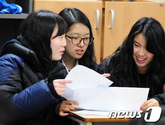 본문 이미지 - 한 여자고등학교에서 수험생들이 2014학년도 수능성적표를 받아 확인하고 있다. / 뉴스1 © News1 김대웅 기자
