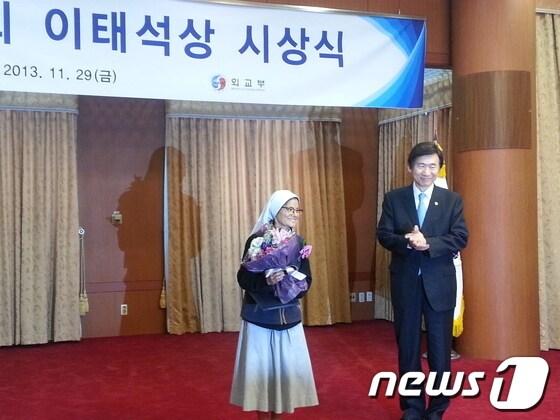 본문 이미지 - 제3회 '이태석상' 수상자인 박정수 수녀(왼쪽)가 상패를 받고 기념사진을 찍고 있다. 오른쪽은 윤병세 외교부 장관. © News1   조영빈 기자