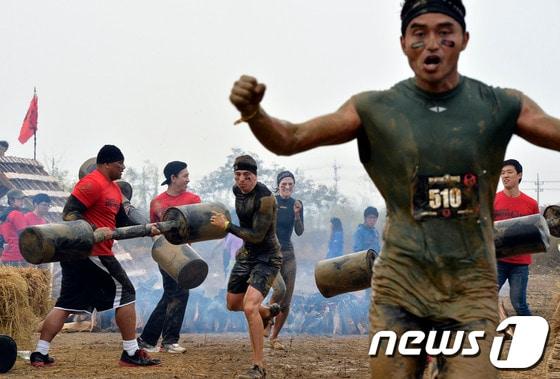 본문 이미지 - 3일 오전 고양시 일산동구 한류월드 K-POP공연장에서 열린 리복 스파르탄 레이스 코리아 대회에 참가한 참가자들이 펀치세례를 맞으며 결승선으로 들어오고 있다. 리복 스파르탄 레이스는 미국과 호주, 멕시코, 슬로바키아 등 전 세계 각 나라와 도시를 돌아가며 한 해 동안 약 65회를 진행, 75만 명의 참가자들이 경쟁하고 있는 이색 장애물 통과 경기로 아시아에서 처음으로 열렸다.2013.11.3/뉴스1 ⓒ News1