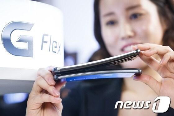 본문 이미지 - 모델들이 5일 오전 서울 여의도 LG트윈타워에서 휘어진&#40;커브드&#41; 스마트폰 &#39;G플렉스&#39;를 선보이고 있다.LG그룹의 역량이 결집된 이 제품은 플라스틱 유기발광다이오드&#40;OLED&#41; 공법으로 제작된 세계 최대 6인치 커브드 디스플레이와 휘어진 곡면형 3500밀리암페어&#40;mAh&#41; 배터리를 탑재했다. 2013.11.5/뉴스1 © News1   유승관 기자