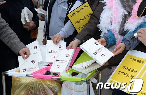 본문 이미지 - 참여연대, 민주노총 등 시민사회단체들이 6일 서울 광화문광장에서 열린 '박근혜 정부 공약파기 규탄 기자회견'에서 정책공약집을 쓰레기통에 버리는 퍼포먼스를 하고 있다. 2013.11.6/뉴스1 © News1 박지혜 기자