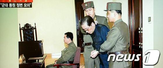 본문 이미지 - 북한 조선중앙통신은 최근 숙청이 결정된 장성택 전 북한 국방위원회 부위원장이 지난 12일 열린 특별군사재판 후 즉각 사형을 당했다고 13일 밝혔다. 통신이 밝힌 장성택의 혐의는 공화국 인민주권을 뒤집을 목적으로 감행한 국가전복음모행위로 공화국형법 제60조에 근거했다.사진은 포승줄에 양 손이 묶인 장성택이 국가안전보위부원들에게 붙들린 채 법정에 선 모습. &#40;YTN 화면캡쳐&#41; 2013.12.13/뉴스1 © News1 &#40;서울=뉴스1&#41;