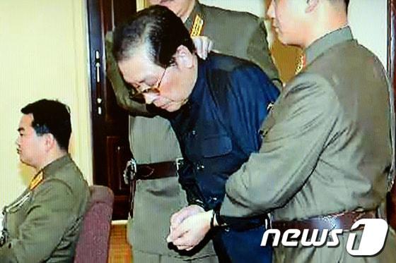 본문 이미지 - 북한 조선중앙통신은 최근 숙청이 결정된 장성택 전 북한 국방위원회 부위원장이 지난 12일 열린 특별군사재판 후 즉각 사형을 당했다고 13일 밝혔다.통신이 밝힌 장성택의 혐의는 공화국 인민주권을 뒤집을 목적으로 감행한 국가전복음모행위로 공화국형법 제60조에 근거했다.사진은 포승줄에 양 손이 묶인 장성택이 국가안전보위부원들에게 붙들린 채 법정에 선 모습. (YTN 화면캡쳐) 2013.12.13/뉴스1 © News1 (서울=뉴스1)