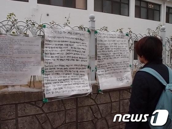 본문 이미지 - 16일 오전 조선대 후문 벽에 '안녕하십니까' 대자보가 붙은 가운데 한 학생이 대자보 내용을 꼼꼼히 읽고 있다© News1 박준배 기자 