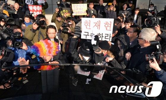 본문 이미지 - 동양증권 피해자들이 지난해 12월19일 오전 서초구 서울중앙지검에서 사기성 기업어음&#40;CP&#41; 발행 의혹을 받고 검찰에 3차 소환된 현재현 동양그룹 회장을 태운 차량 앞에서 항의하고 있다. /뉴스1© News1 박세연 기자