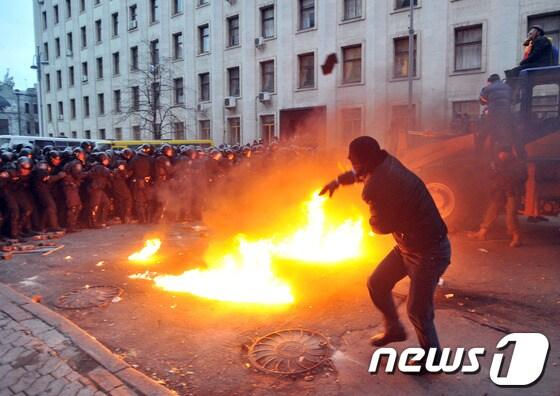 본문 이미지 - 지난 1일(현지시간) 우크라이나 수도 키예프에서 열린 반정부시위에서 한 시위대원이 경찰을 향해 화염병을 던지고 있다.© AFP=News1